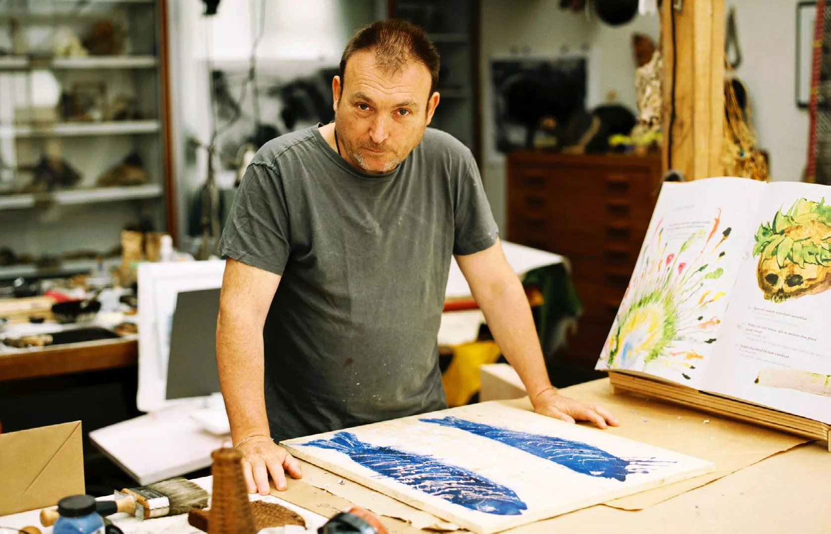 Miquel Barceló al seu taller de París. A la imatge, una de les pàgines dobles del llibre i el dibuix dels peixos que decora la caixa de fusta que també fa de faristol