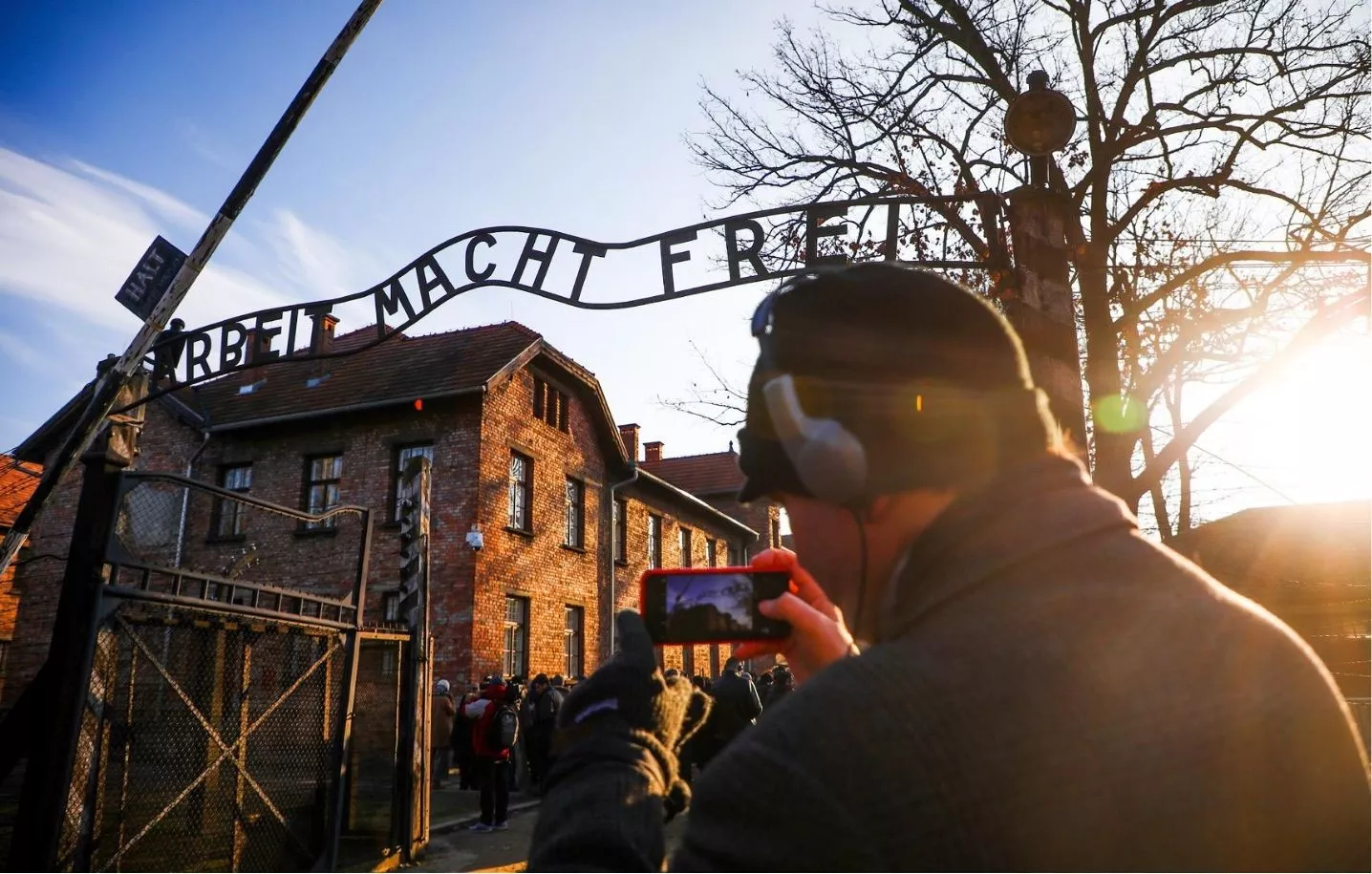 Un turista fa una fotografia a la porta d'entrada al camp d'Auschwitz-Birkenau