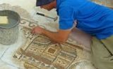 Un treballador amb el mosaic descobert -  Nikki Davidov. Israel Antiquities Authority