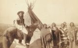 Un grup d'índies natives davant d'un tipi, l'hàbitat de les tribus indígenes de les planes nord-americanes Un grup d'índies natives davant d'un tipi, l'hàbitat de les tribus indígenes de les planes nord-americanes